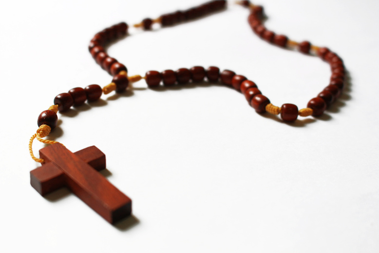 Brown Rosary on White Surface